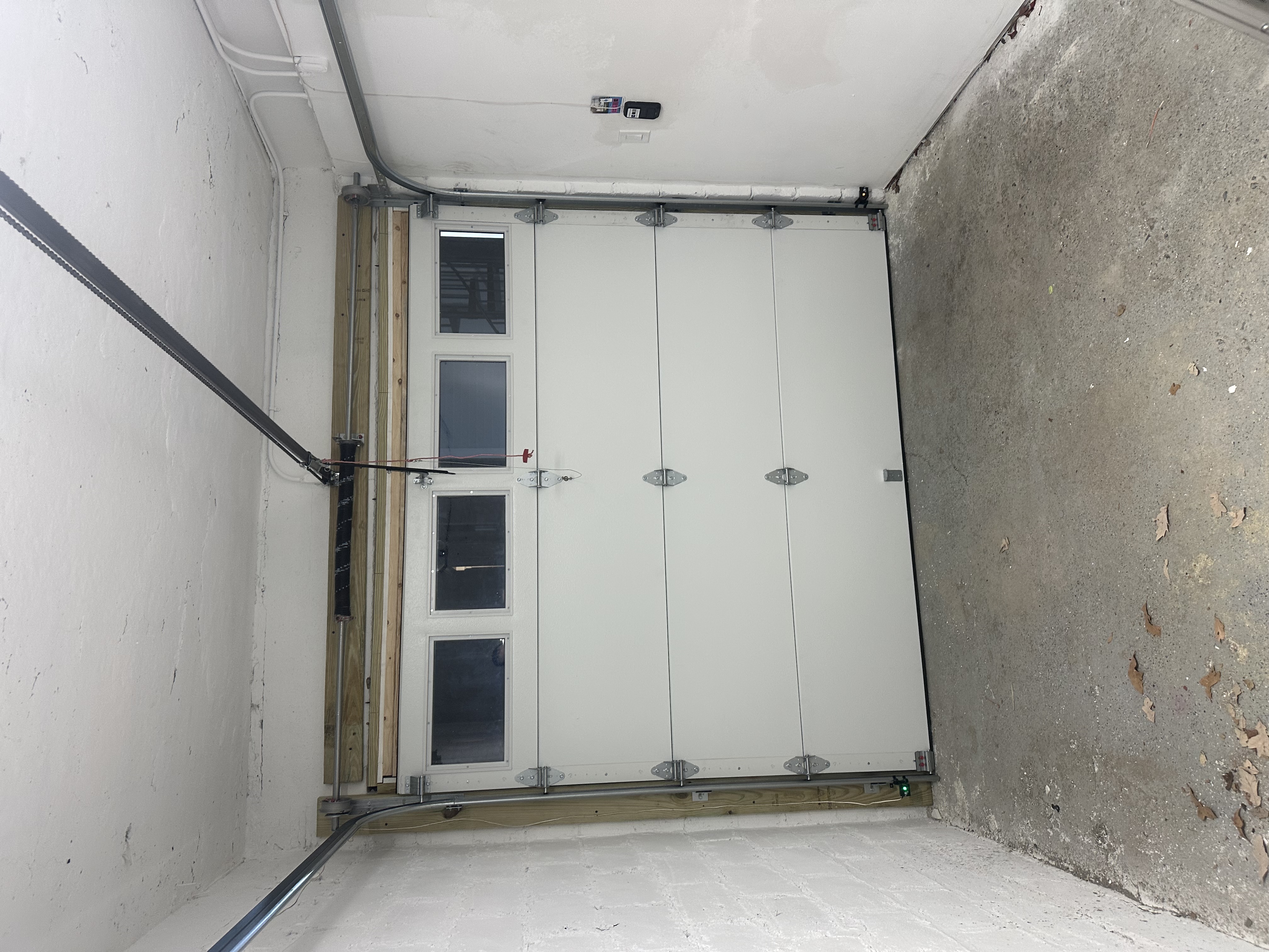 White insulated garage door installation in a finished garage